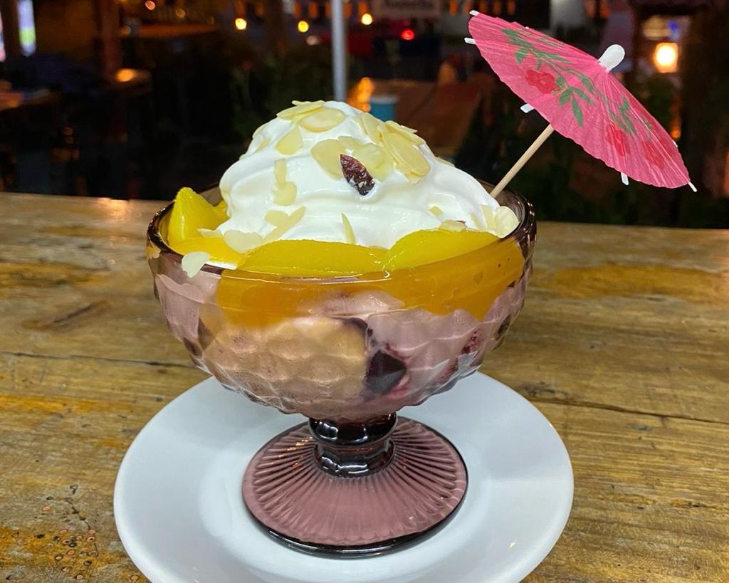 Postre frío de durazno llamado Peach Melba en su presentación de copa